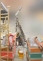 Musical instruments accordions and saxophone in daylight, blurred background