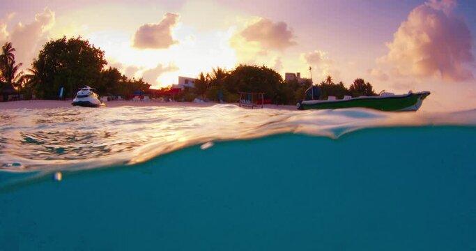 Split view of the tropical sea and island during sunset in the Maldives