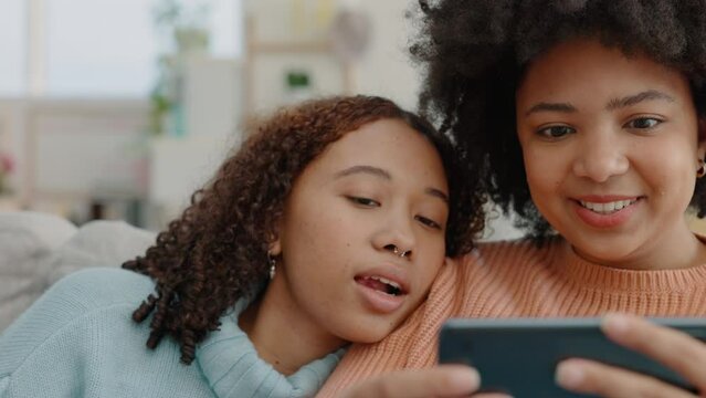 Women, afro or phone streaming and bonding in house living room or home interior with comic video film. Happy smile friends, lgbtq couple or family sisters watching internet movie on subscription app