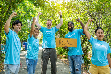 volunteering, charity, people, gesture and ecology concept - group of happy volunteers showing thumbs up and greeting you in park