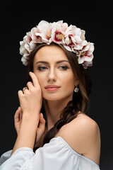 Beautiful young brunette woman wearing a delicately pink floral wreath. Wedding headdress for girls. Ukrainian beauty