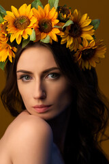 Fototapeta premium Portrait of a Ukrainian girl in a wreath of colorful yellow sunflowers. National traditional flower headdress. Ukraine concept. Stop war