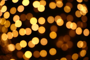 Many yellow blurry bokeh light on dark background in Christmas and New Year festival day, can use for background