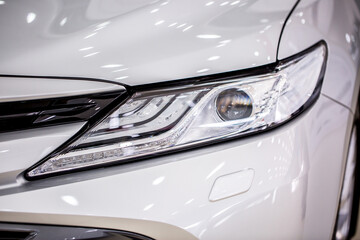 Toyota. Headlight of modern prestigious car close up. Brilliant glass car headlight with highlights from the lighting in the showroom. Sale of new commercial cars. Shymkent Kazakhstan April 15, 2022