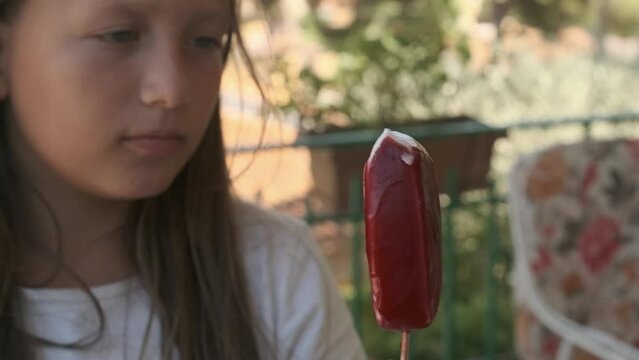 a girl eats a popsicle