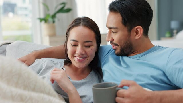 Couple, watching tv and television with coffee in living room with blanket and funny comedy movie, online streaming or video. Relax, love and cozy comfort of man and woman with film on couch or sofa.