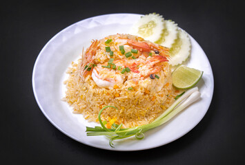 Thai fried rice with shrimp, green onions, lime,  in a black background
