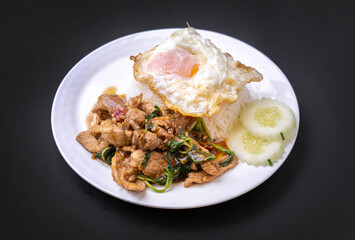 Thai spicy food basil pork fried rice recipe with fried egg  (Krapao Moo) on black