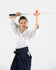 Aikido master woman in traditional samurai hakama kimono with black belt with sword, katana on white background. Healthy lifestyle and sports concept.