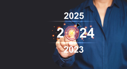Businessman pointing to digital 2024 calendar on virtual screen while standing on a gray background