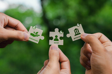 ESG Concepts on Environment, Society and Governance In hand holding puzzle pieces that come...
