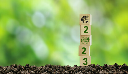 Happy new year 2023 with wooden block with green net zero icon aiming for a sustainable future of...