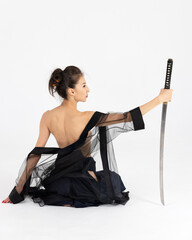 Aikido master woman in traditional samurai hakama kimono with black belt with sword, katana on white background. Healthy lifestyle and sports concept.