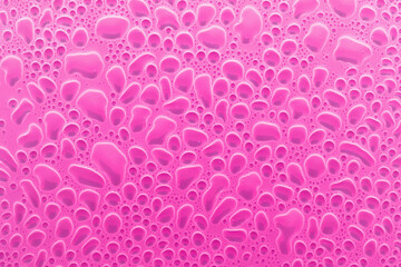 Colorful abstract pattern of round bubbles or droplets as cells under microscopy in saturated pink color, top view. Abstract background in microbiology, biomorphic style or rounded and liquid forms.