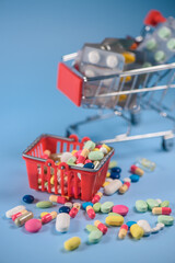 Fototapeta na wymiar Buy medicine. Shopping basket with various medicinal, pills, tablets on blue background. Studio Photo