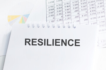 RESILIENCE inscription on a sheet of notepad on the office desk among the documents