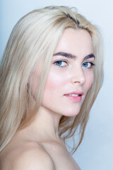 Naklejka premium Closeup profile portrait of a smiling young woman with blonde hair, isolated white background.
