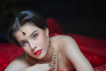 Beautiful portrait fashion of a young Asian woman in traditional Hindu Red Saree wedding clothes with bride dress makeup and jewelry gorgeous red bridal. - obrazy, fototapety, plakaty