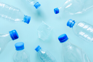 Plastic trash on a blue background. The concept of environmental pollution. Selective focus in the center of the frame