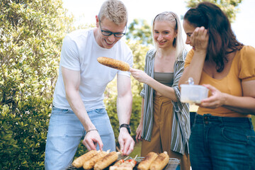 Happy family cheering with barbecue dinner outdoor - Group of people having fun at weekend meal - BBQ Food, taste and summer concept, Man cooking meat on barbecue grill at summer party