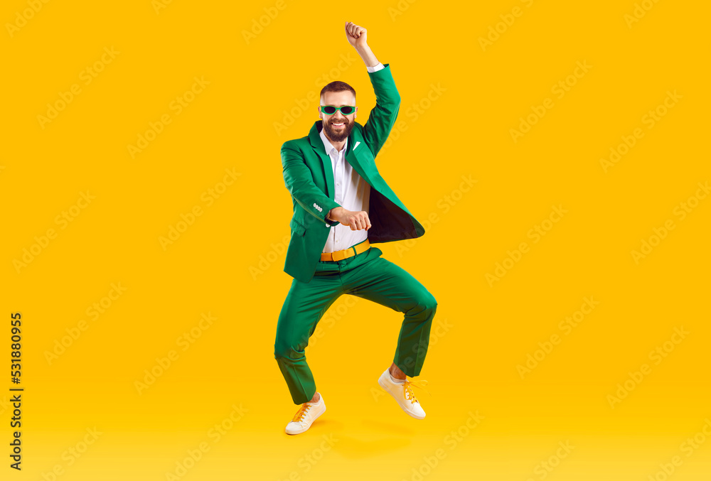 Wall mural cheerful energetic man has fun dancing in gangnam style at st. patrick's day party. full length of m