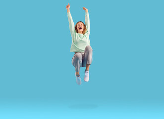 Joyful excited woman clenching her fists rejoicing in her victory or success jumping in air. Happy...