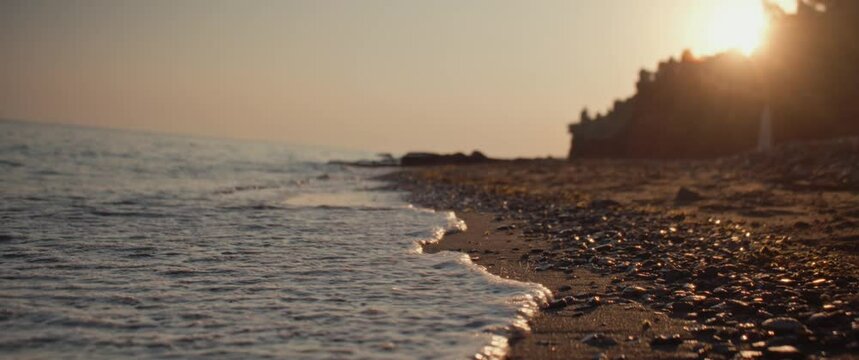 Waves of beach hitting the shores during a beautiful sunset
