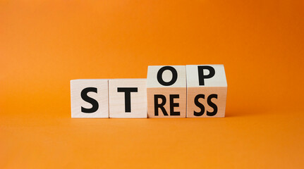 Stop and Stress symbol. Turned wooden cubes with words Stress and Stop. Beautiful orange...