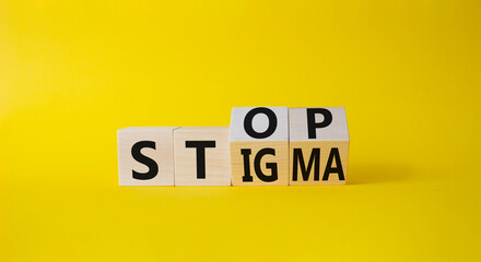 Stop and Stigma symbol. Businessman hand points at wooden cubes with words Stop and Stigma....