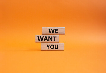We want you symbol. Concept words We want you on wooden blocks. Beautiful orange background. Business and We want you concept. Copy space.