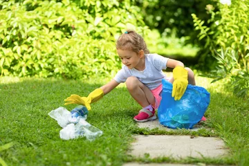 Girl collection plastic garbage in nature. kid picking up trash in park. Earth Day April 22. Save planet. Young volunteer child cleaning forest environment from rubbish pollution. World Environment  © Елена Якимова