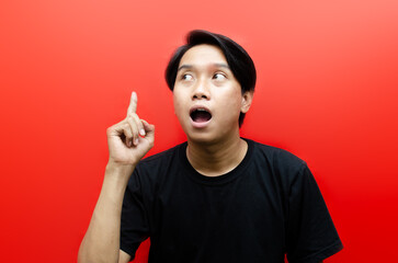 Young asian Man Pointing Finger Up with surprised expression. great idea concept. aha I have an idea expression.