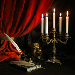  Dramatist's workplace with quill, ink, candelabra, antique book and theatrical mask with dark red curtain. Vintage writing set concept.  - obrazy, fototapety, plakaty