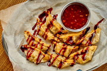 Japanese gyoza in teriyaki sauce. Selective focus. Close-up. Noise added in post-production