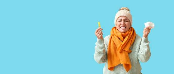 Stressed mature woman with clothespin and tissue on blue background with space for text. Stuffy nose concept