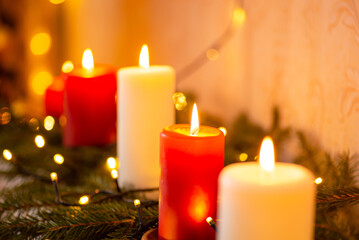 Line of burning red and white candles on fir tree branches. Christmas background of decorations
