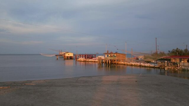 Aerial view of fishing huts on shores of estuary at sunset,italian fishing machine, called "trabucco",Lido di Dante, Ravenna near Comacchio valley.