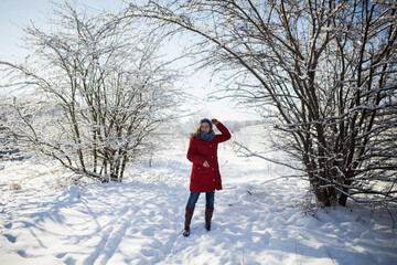 Kobieta na zimowym spacerze, wszędzie leży biały puszysty śnieg - obrazy, fototapety, plakaty