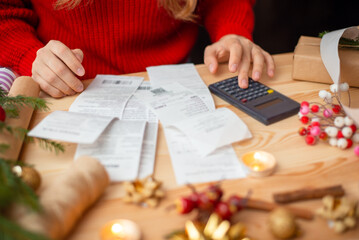 Close-up shot of checks, bills and receipts on wooden table and girl counting them. Concept of much...