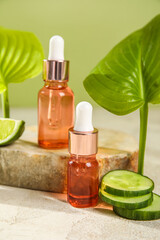 Bottles of essential oil and cucumber slices on table
