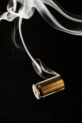 Cartridge cases with smoke falling on black background