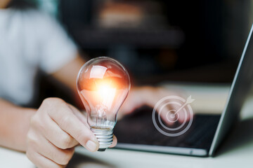 Businessman using laptop and hand holding light bulb. idea concept  from online technology with creativity, creative, innovation, inspiration and problem solving solution.