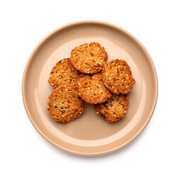 Plate with tasty sesame kozinaki on white background