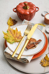 Dinnerware and autumn leaves on light table