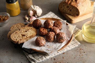 Plate with meat balls, baking paper, bread slices and napkin on grunge background