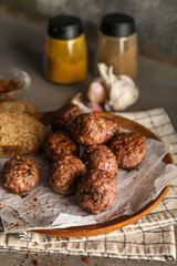 Plate with meat balls, baking paper, bread slices and napkin on grunge background, closeup
