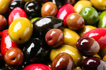 Different kinds of tasty olives as background, closeup