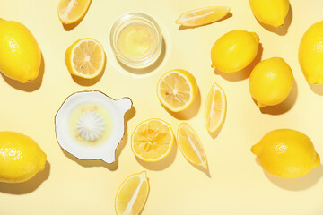 Fresh ripe lemons, juicer and bowl of juice on color background