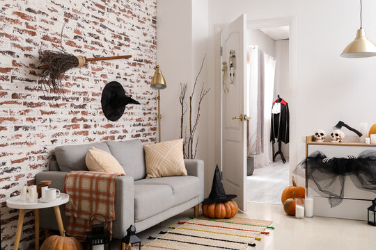 Interior Of Modern Living Room With Sofa, Open Door And Halloween Decor