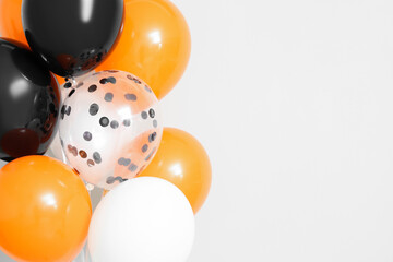 Halloween balloons near light wall, closeup